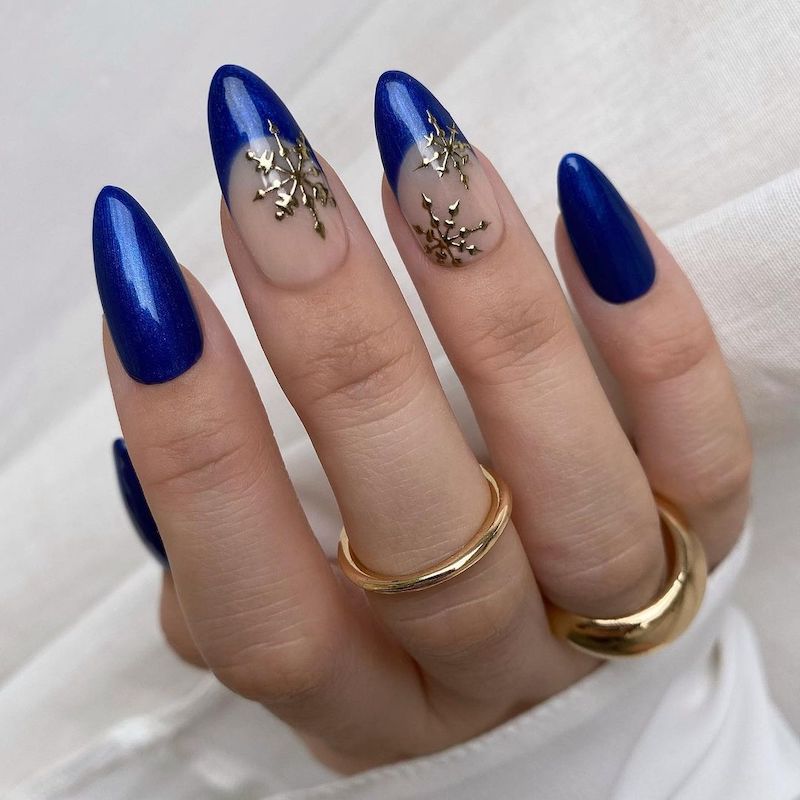 Manicure azul royal com unhas com detalhes em ponta francesa de floco de neve prateado