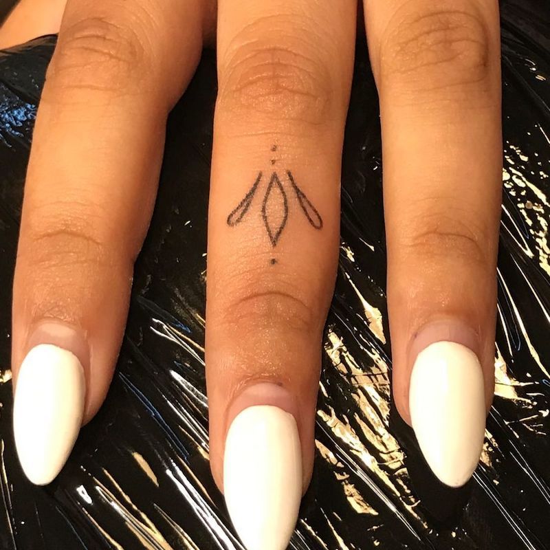 Design simples de tatuagem na forma de formas curvas no dedo médio