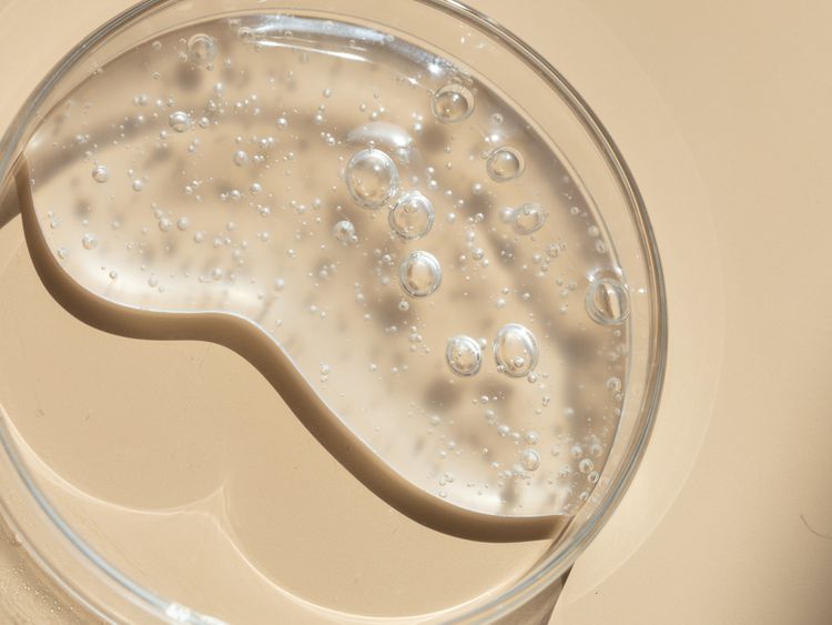 Fecha r-up líquido em uma tigela de vidro em um fundo bege