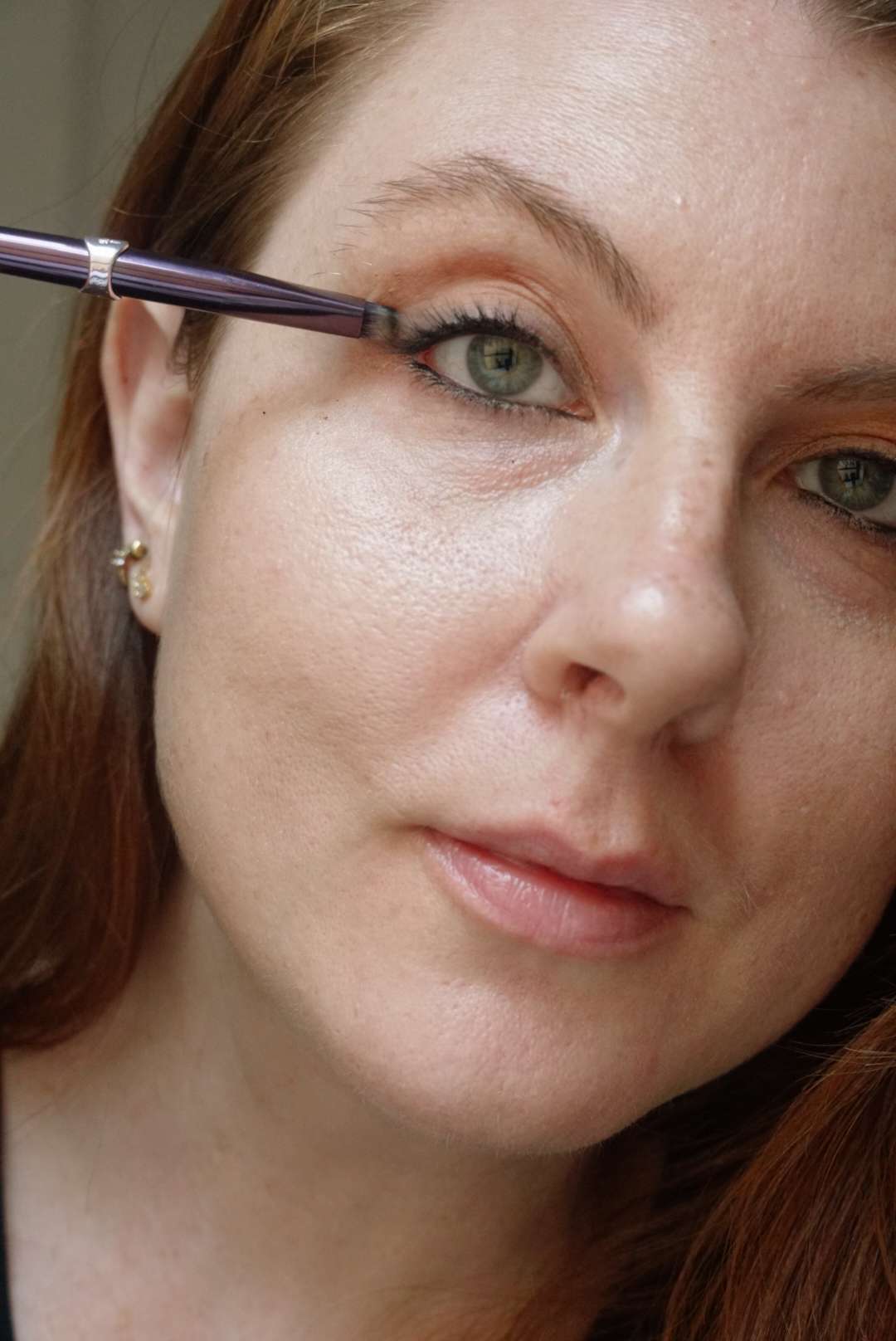 Maquiador e autor Byrdie Ashley Rebecca mistura um delineador com um pincel de maquiagem para os olhos