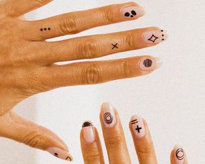 Fecha r-up de duas mãos com tatuagens em unhas e dedos