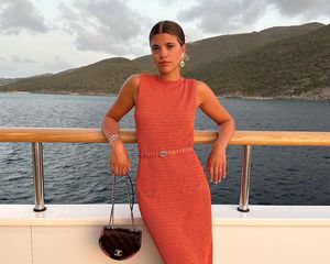 Sofia Richie em um vestido Chanel tecido e uma bolsa Chanel acolchoada em um barco