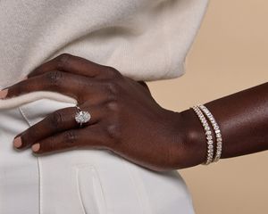 Feche a mão com um anel e pulseiras com diamantes cultivados no laboratório