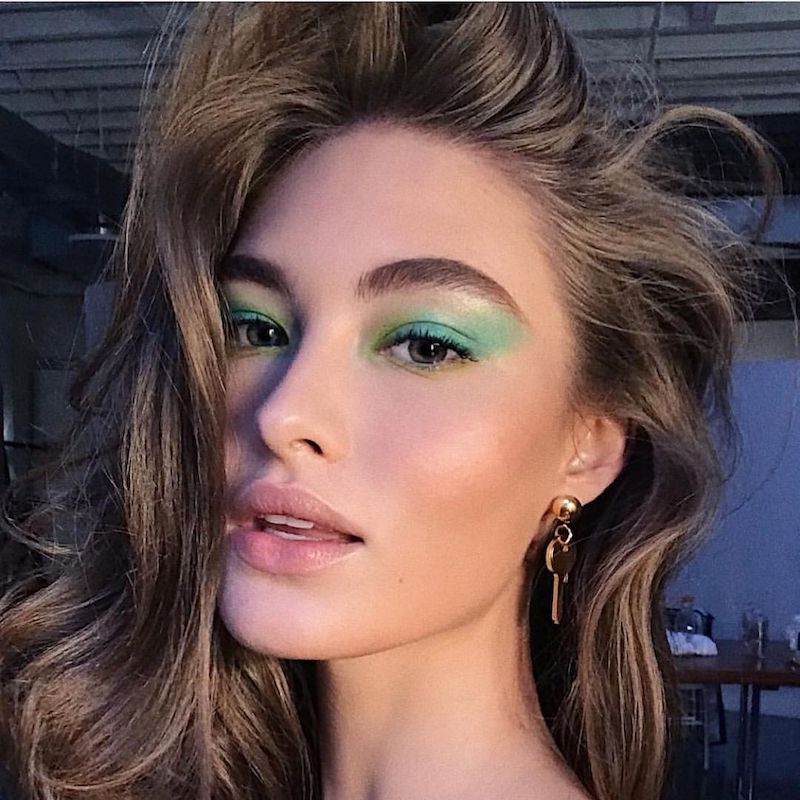 Grace Elizabeth com sombra verde esmeralda, olhos azuis e maquiagem neutra