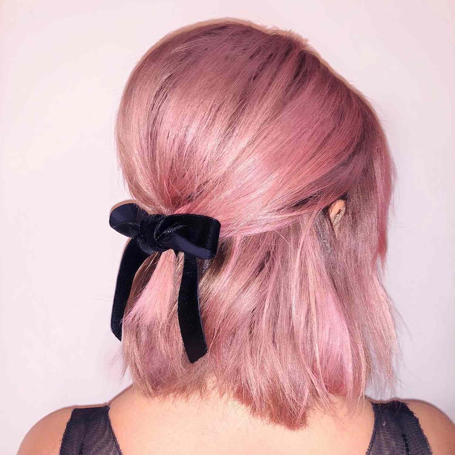 A vista por trás de Ashley Tisdeil com um penteado rosa na forma de um pacote de mei o-aberto com uma fita
