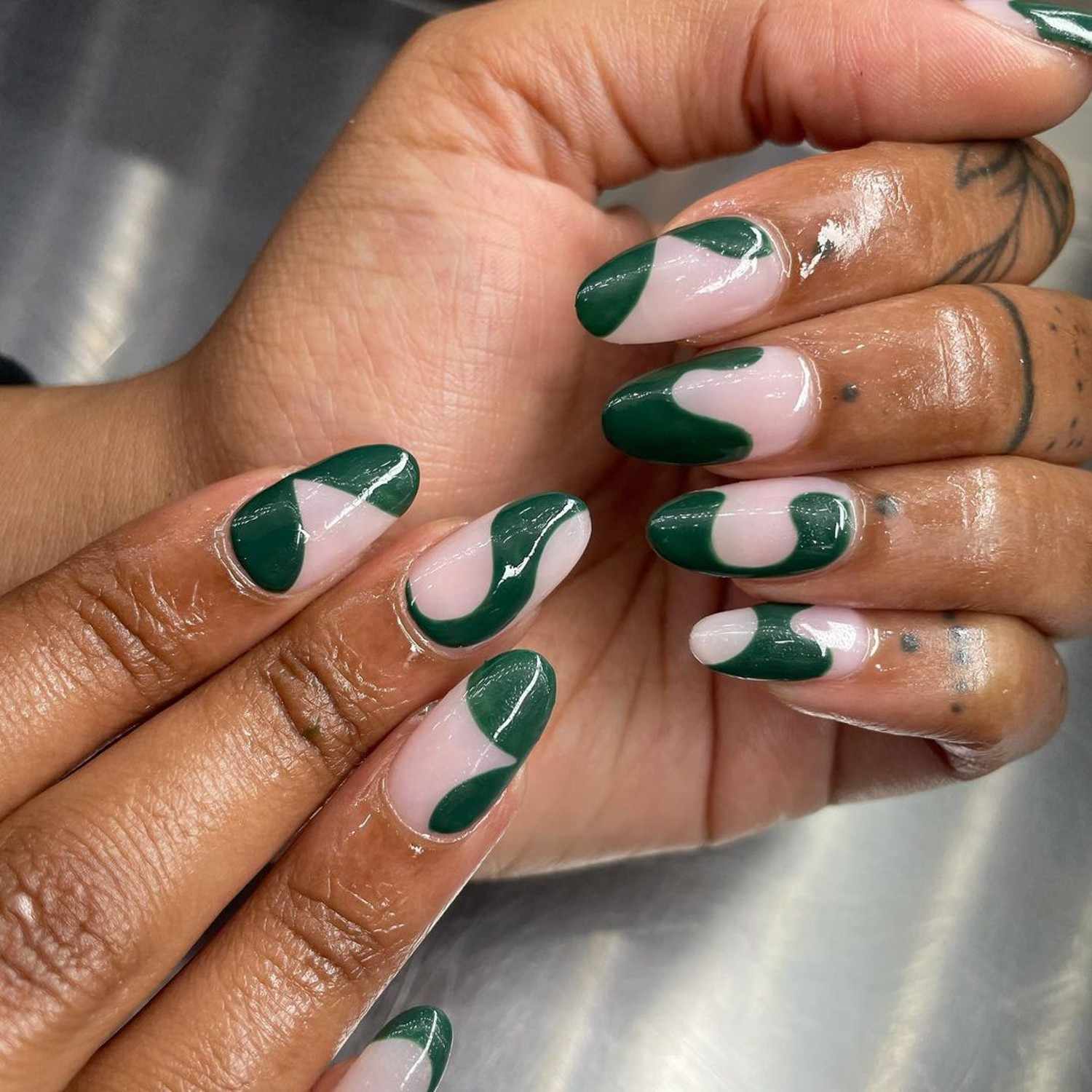 Manicure com um design abstrato verde escuro
