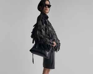 O modelo possui uma jaqueta de bombardeiro com pincéis Phoebe Philo, bolsa de ombro, saia lápis e óculos de sol