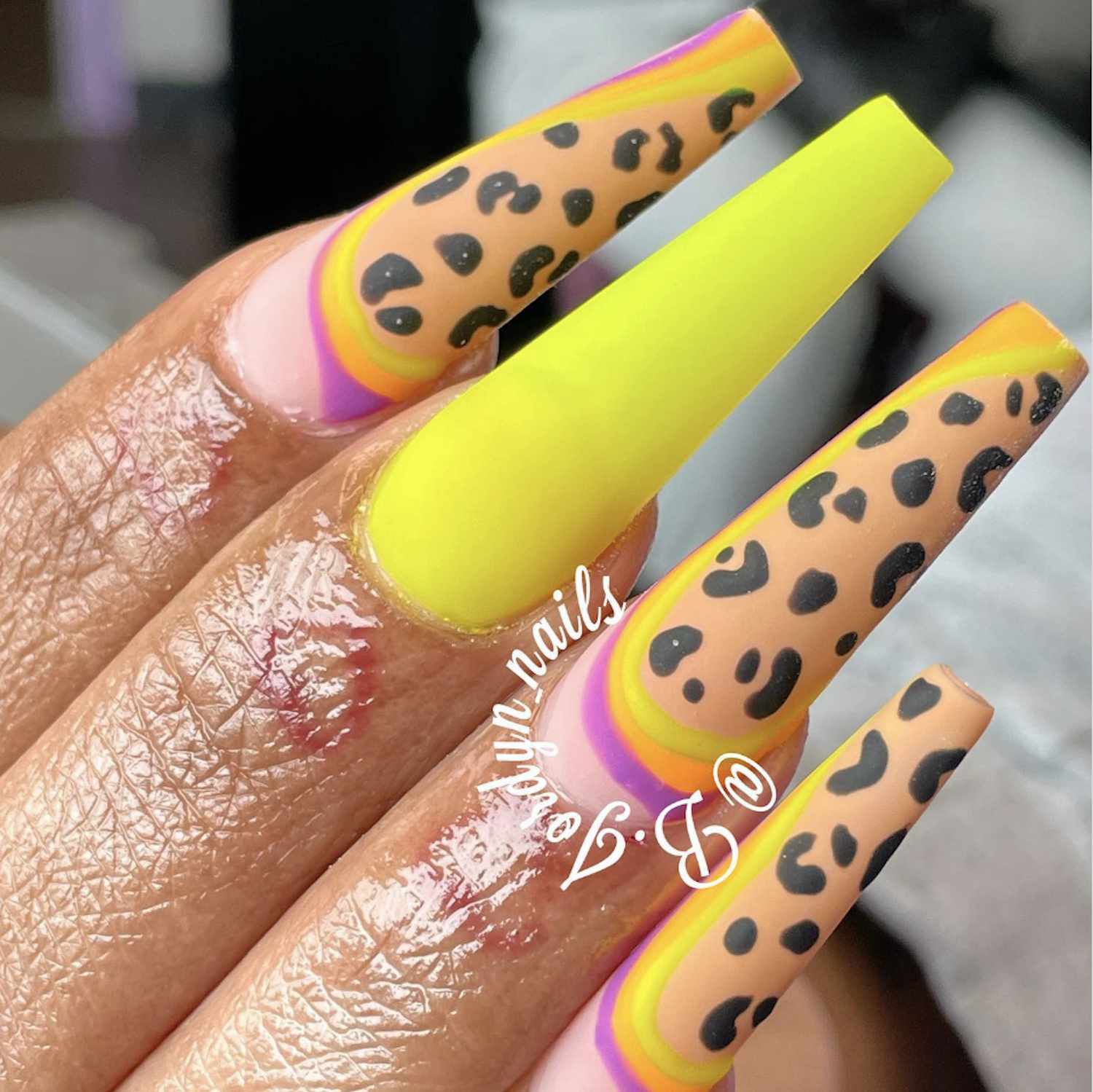 Manicure de leopardo com detalhes amarelos e rosa