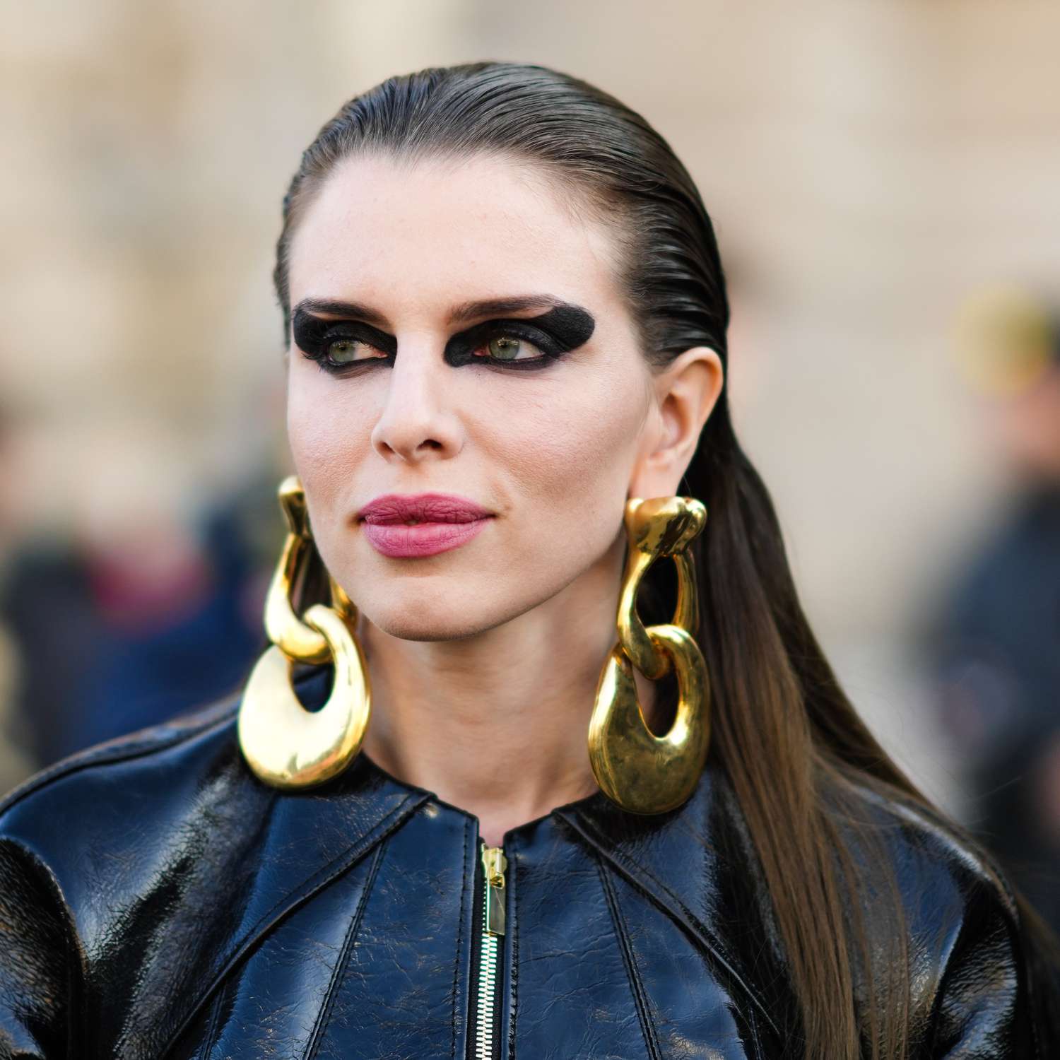 Julia Fox na dramática maquiagem negra dos olhos e brincos de ouro na semana de moda em Paris.