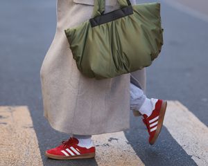 Foto de Adidas Gazelle Red Sneakers com um casaco de lã e uma bolsa verde