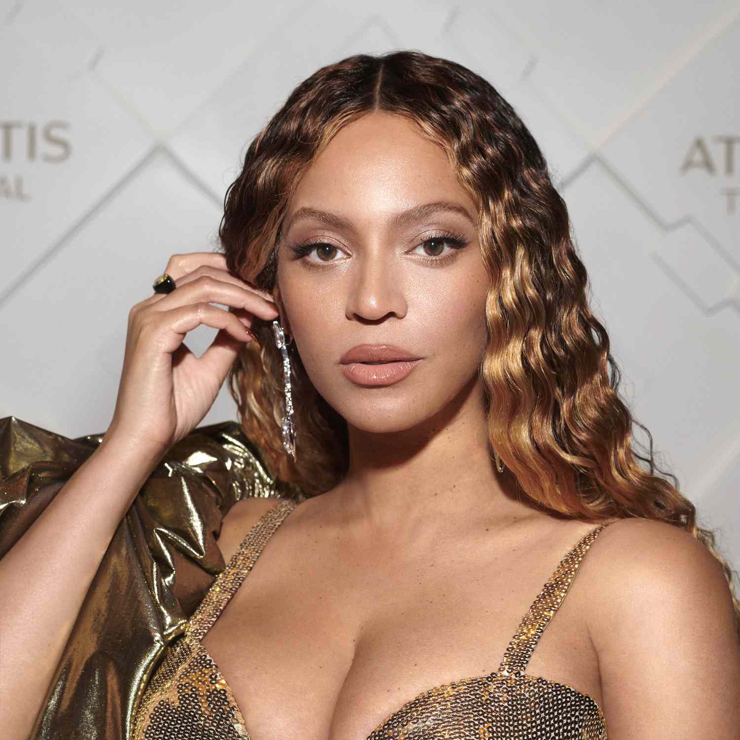 Beyoncé com sobrancelhas arredondadas e cabelos crespos em um vestido dourado no Atlantis The Royal Grand Reveal Weekend