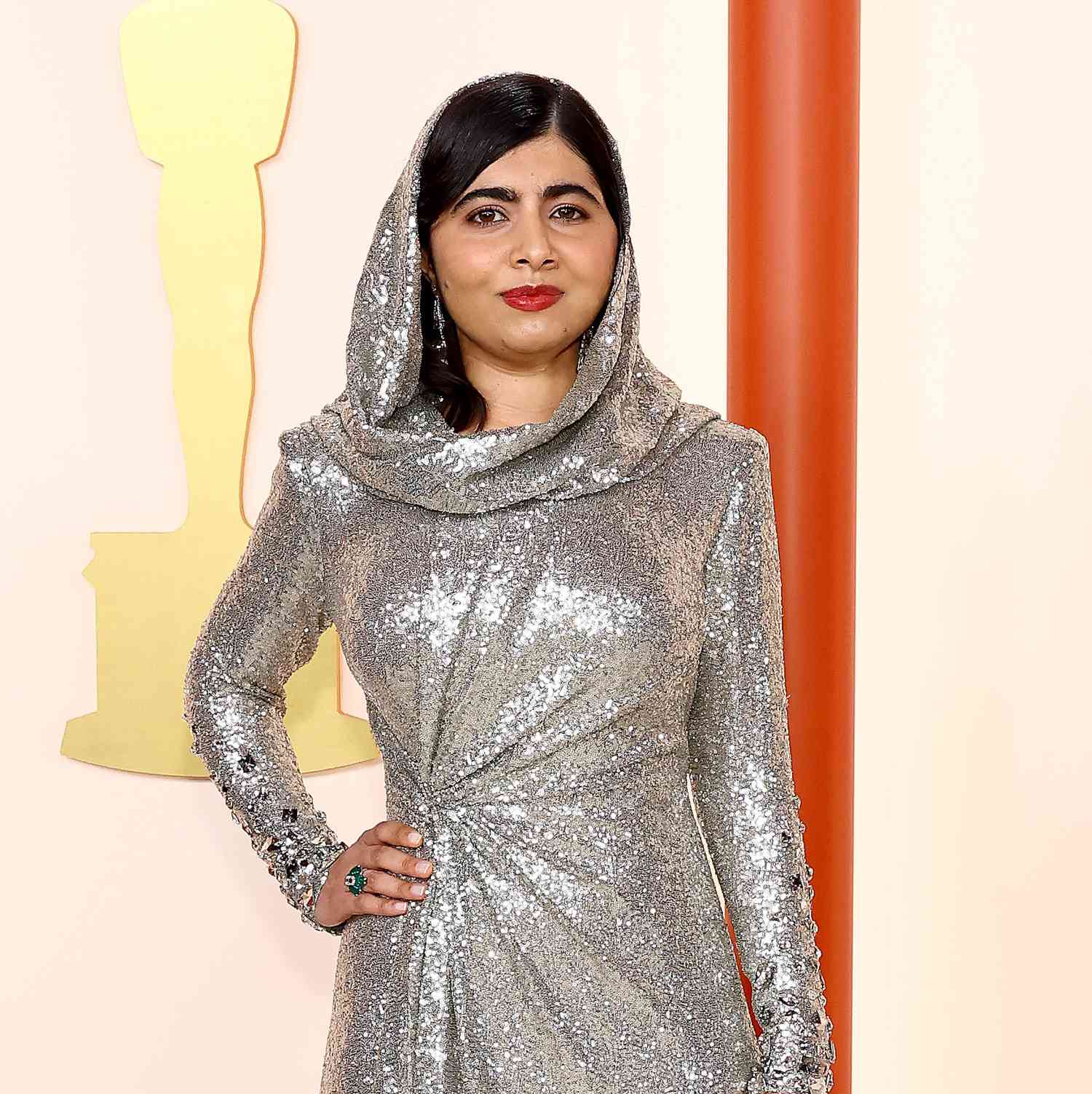 Malala em vestido prateado e lábios vermelhos no caminho do Oscar