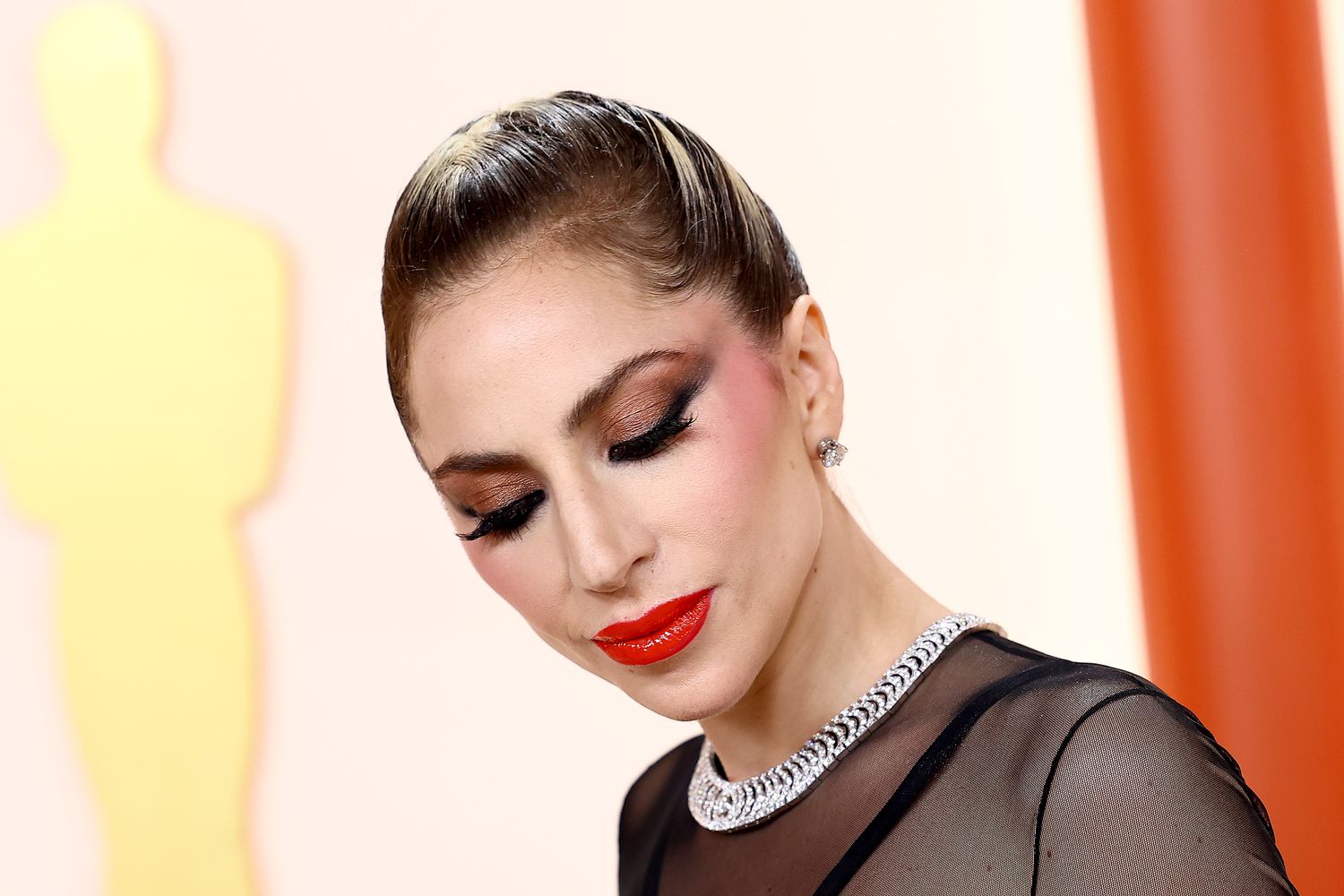 Lady Gaga apareceu no Oscar de 2024 com uma elegante trança francesa, blush rosa e lábios vermelhos brilhantes.