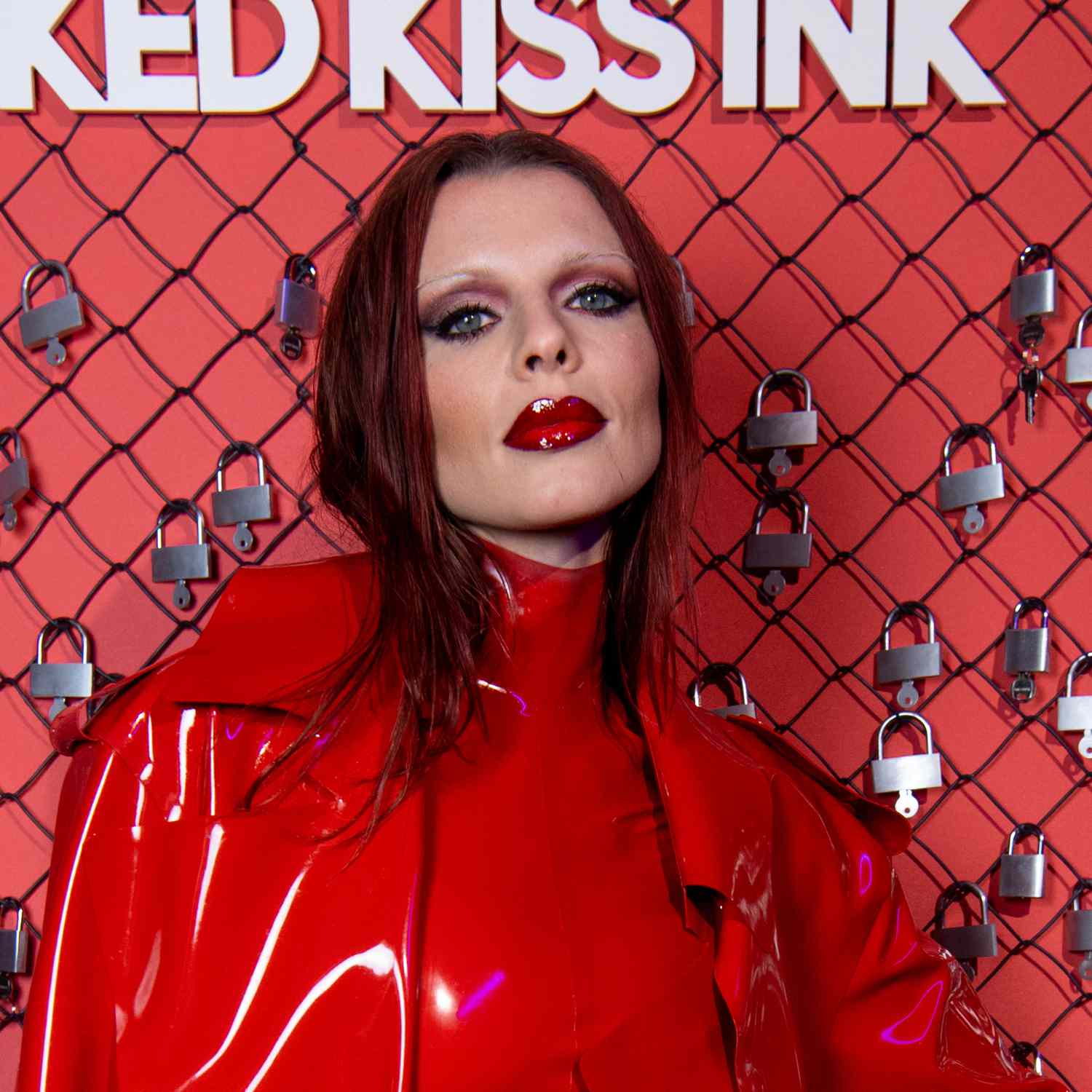 Julia Fox usa tons de defumado vermelho para pálpebras com delineador preto intenso e lábios vermelhos envernizados com sobrancelhas finas