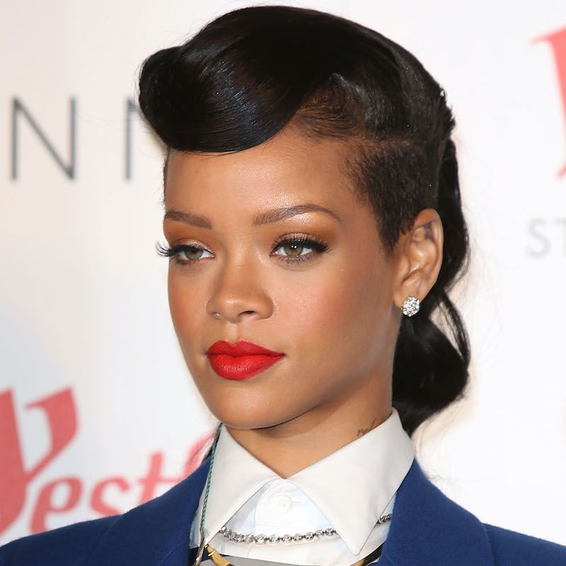 Rihanna em um penteado no estilo dos anos 50 com lateral raspado e batom vermelho