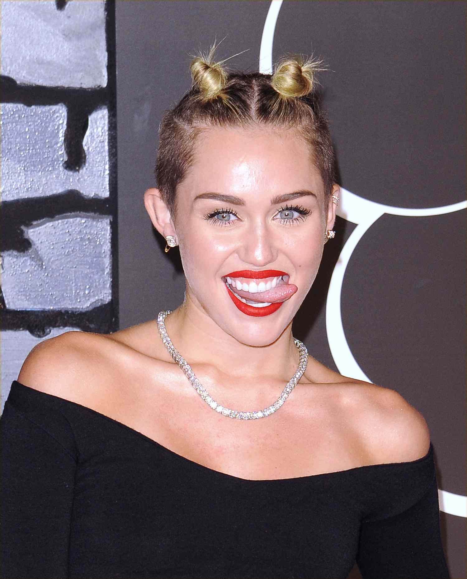Miley Cyrus usa pães infantis com um corte de cabelo baixo.