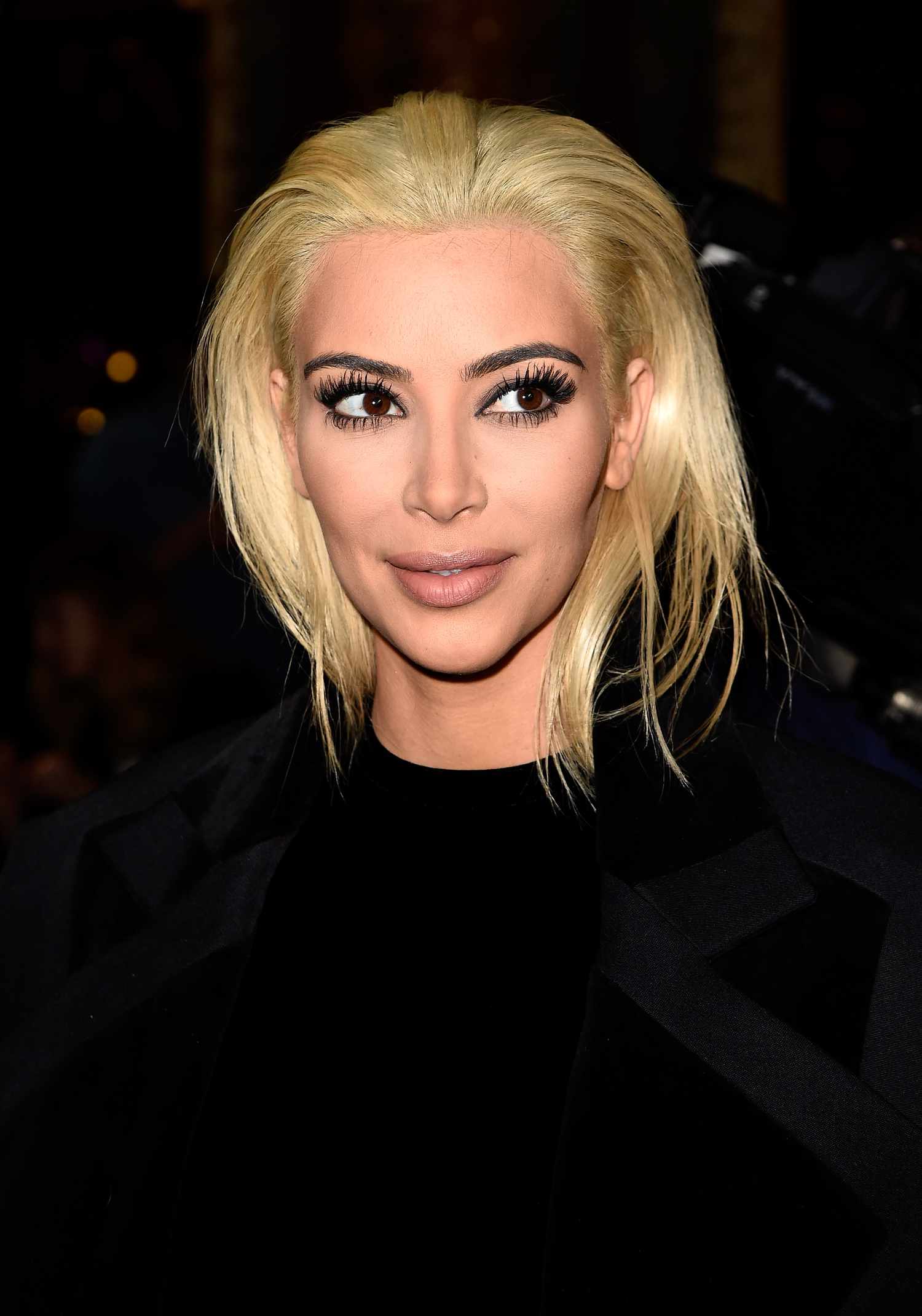Kim Kardashian brilhante e penteado para trás cabelos