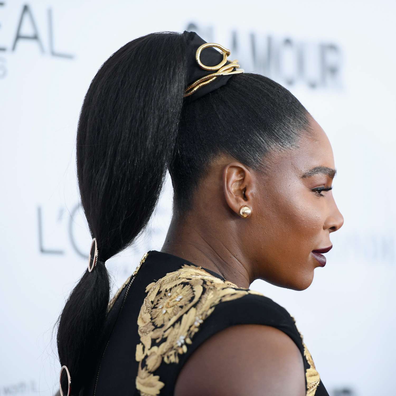 Serena Williams usa um rabo de cavalo alto e elegante com acessórios dourados