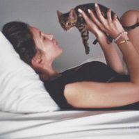 A autora byrdie Tanya Akim segura um gatinho nos braços