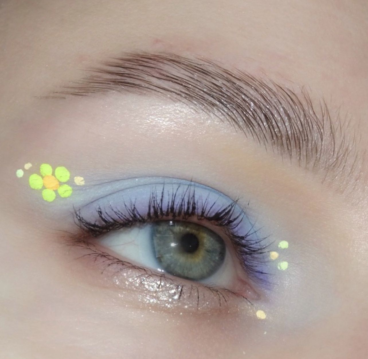 Os olhos azuis são pintados com sombras de pálpebra azul com um delineador de cor Barvinka e detalhes florais neono-amarelos