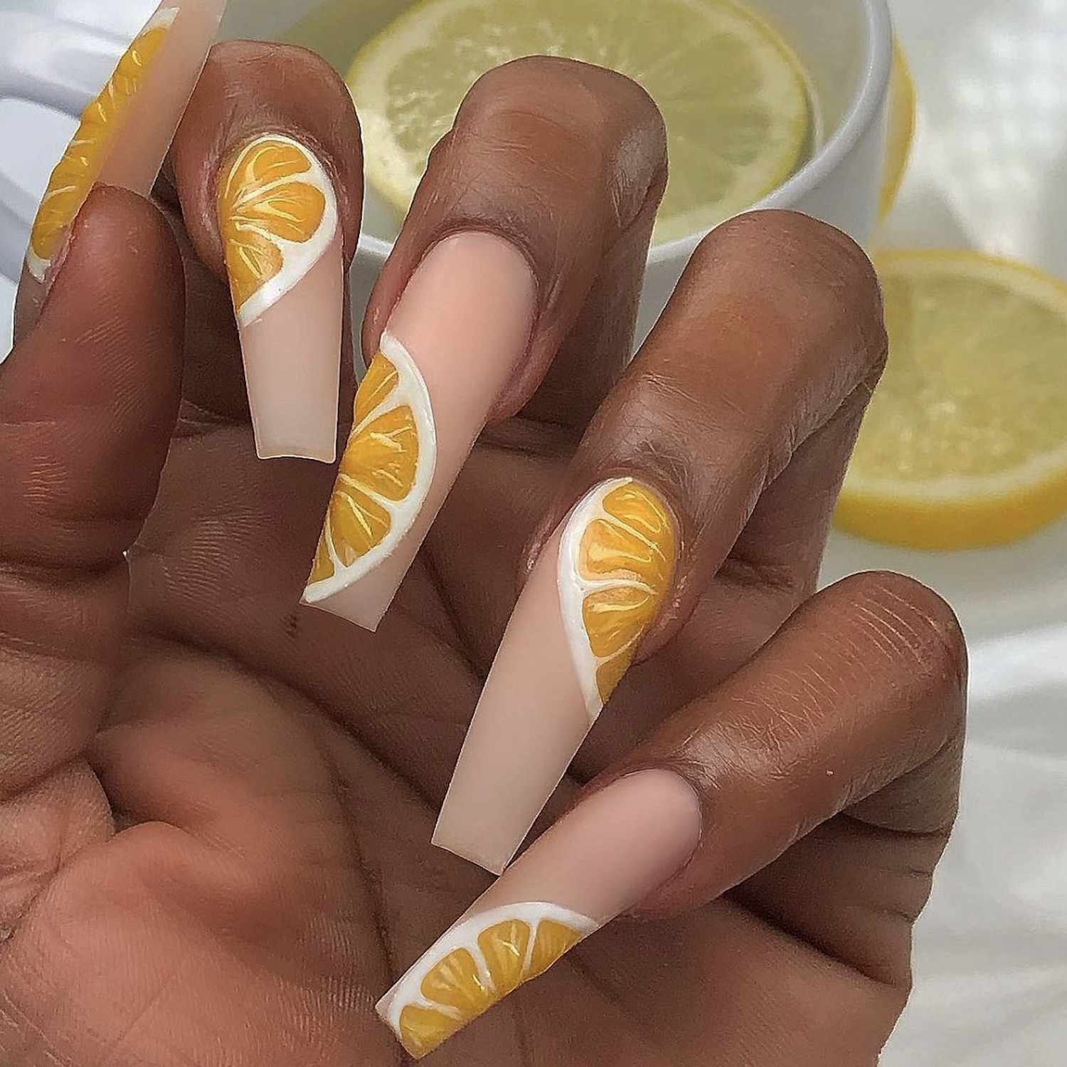 Manicure neutra com detalhes de limão