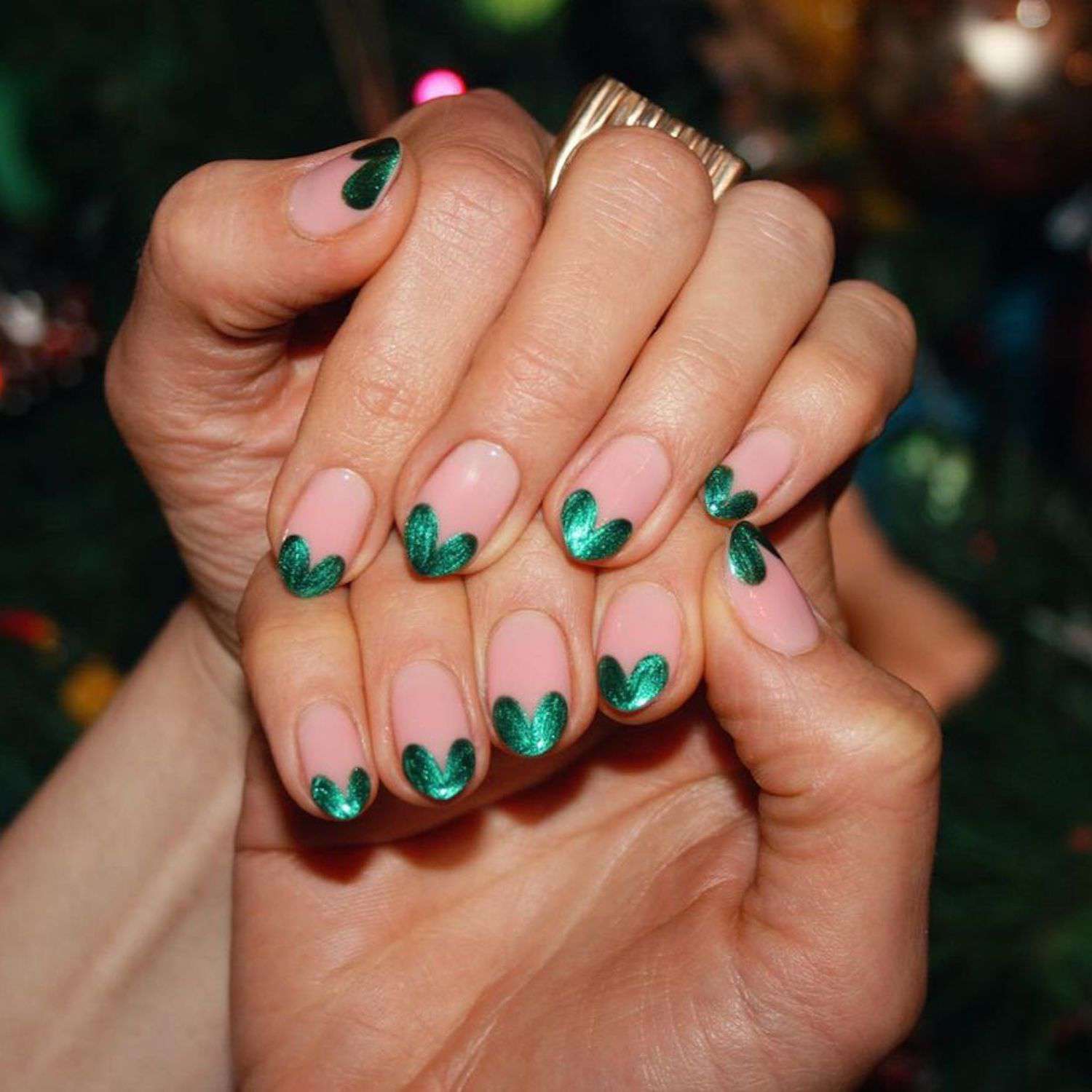 Manicure francesa com corações usando verniz metálico verde escuro