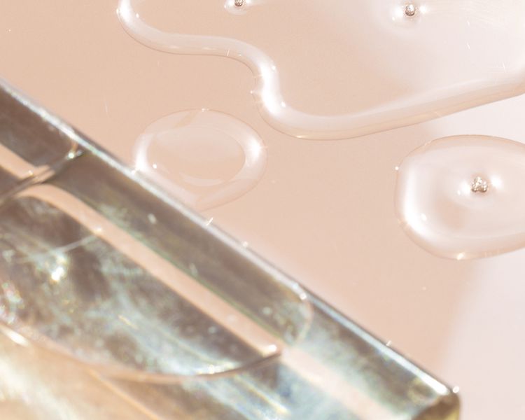 Close-up de líquido para cuidados com a pele em fundo rosa