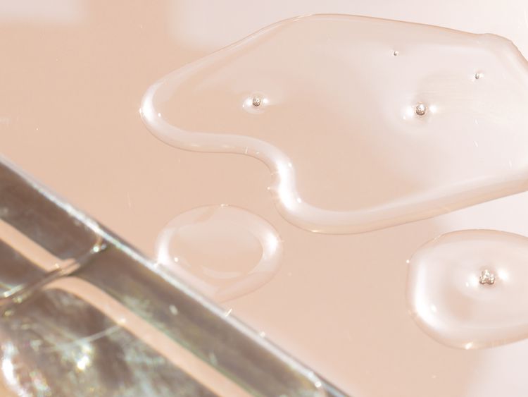 Close-up de gotas de óleo mineral em fundo rosa