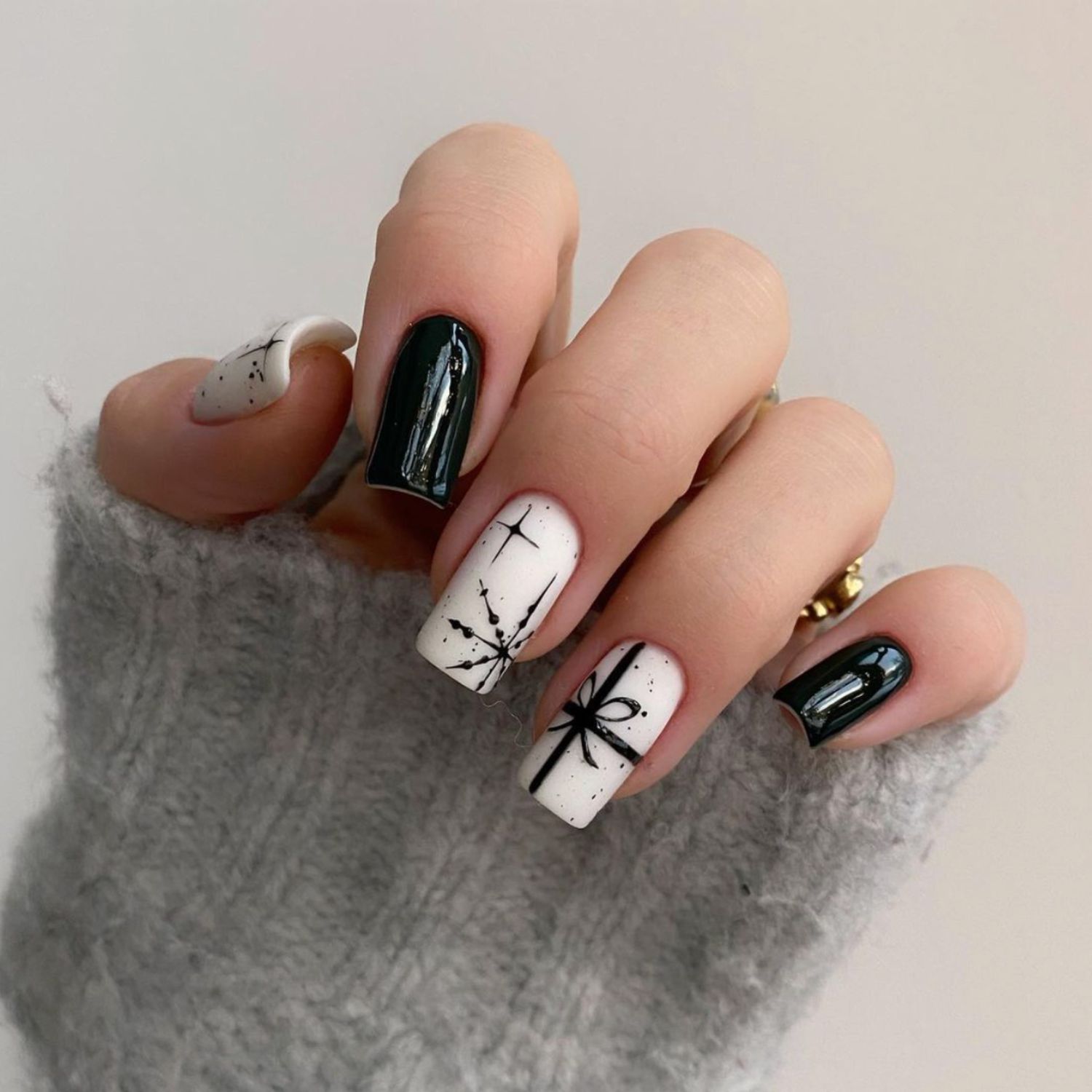 Manicure em preto e branco em close-up com unhas simples, arco e flocos de neve