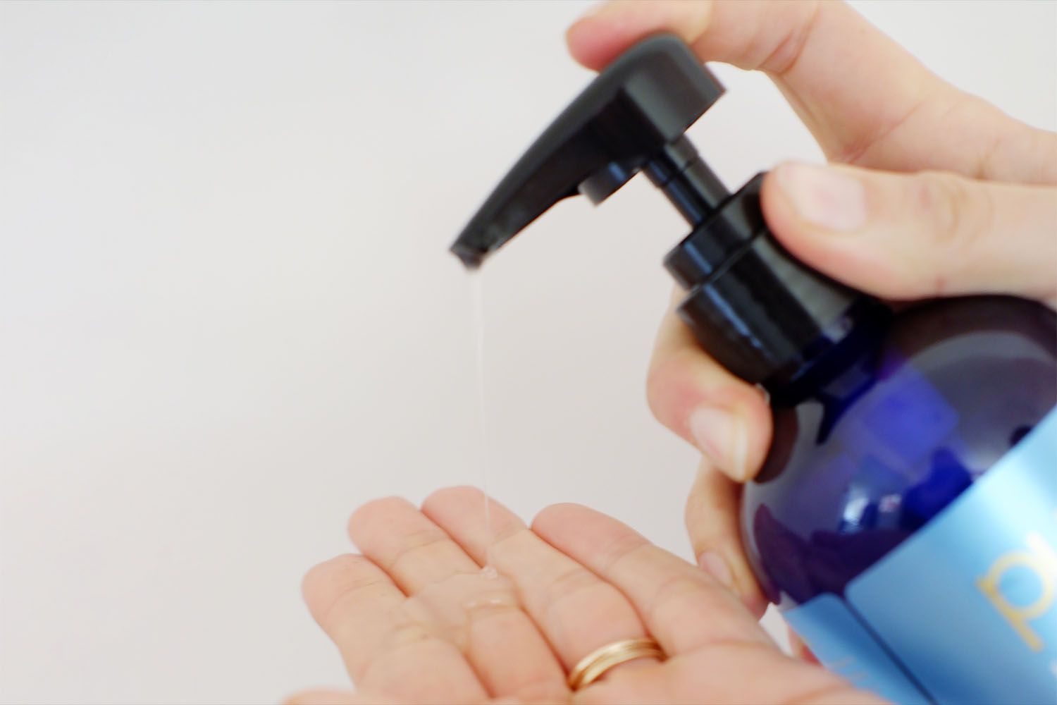 Mão transborda o shampoo de terapia de desbaste de cabelo pura dâor na outra mão