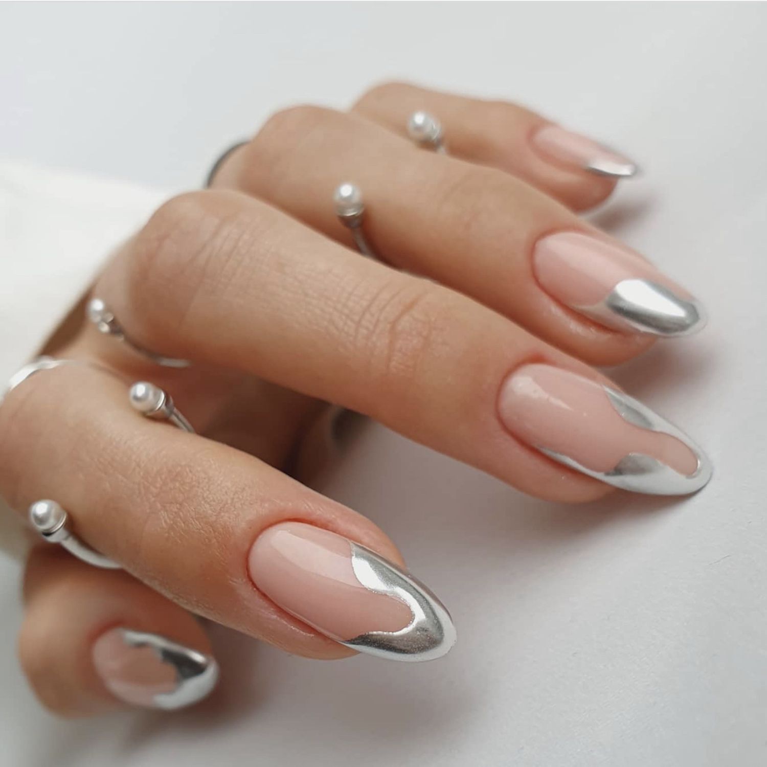 Manicure em close-up com design abstrato de unhas de prata-cromo