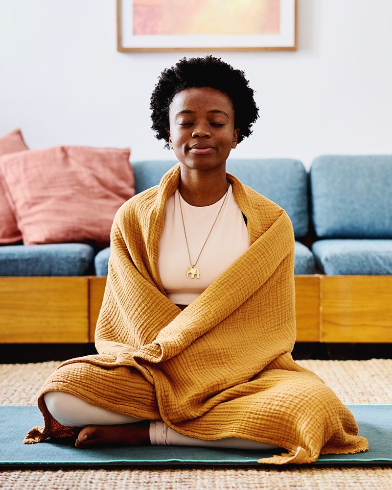 Mulher negra medita no tapete de ioga