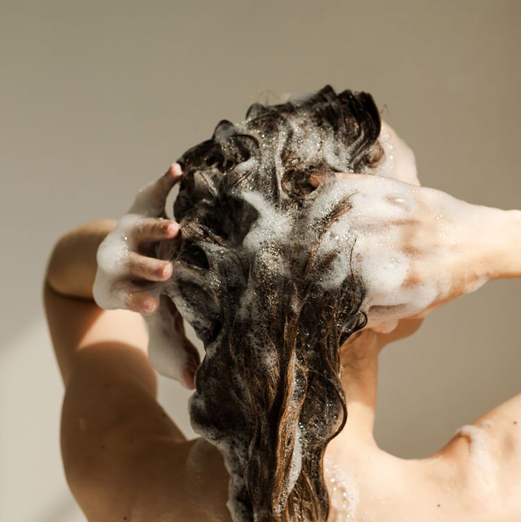 Uma pessoa lava os cabelos atrás do