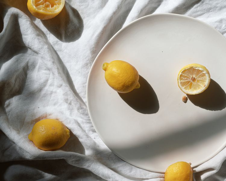 Limões em um prato colorido por creme e guardanapo de marfim