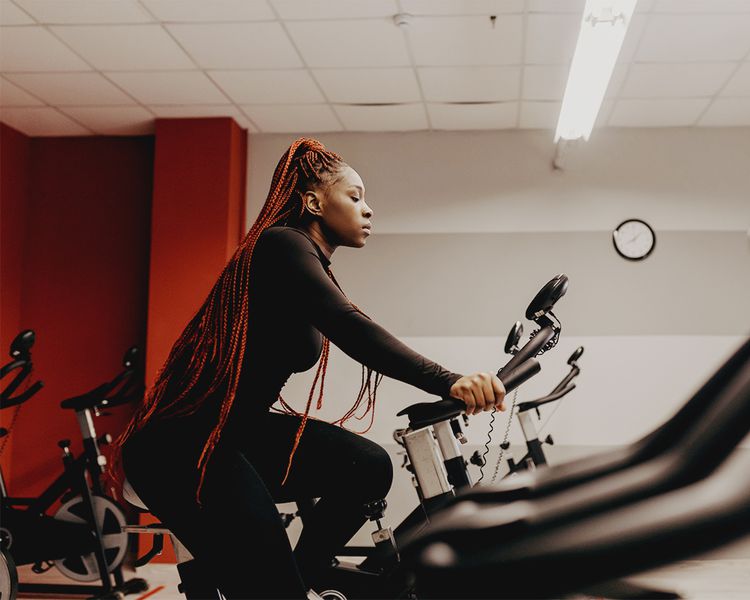 Mulher negra em uma bicicleta de exercício