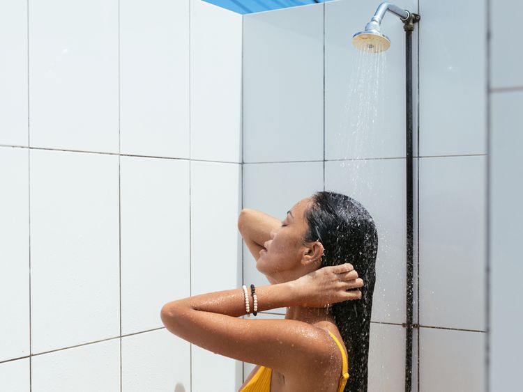 Uma mulher toma banho ao ar livre em uma casa de banho sui