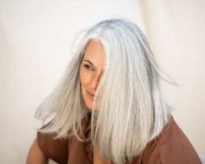 Mulher com cabelo prateado brilhante em um fundo branco