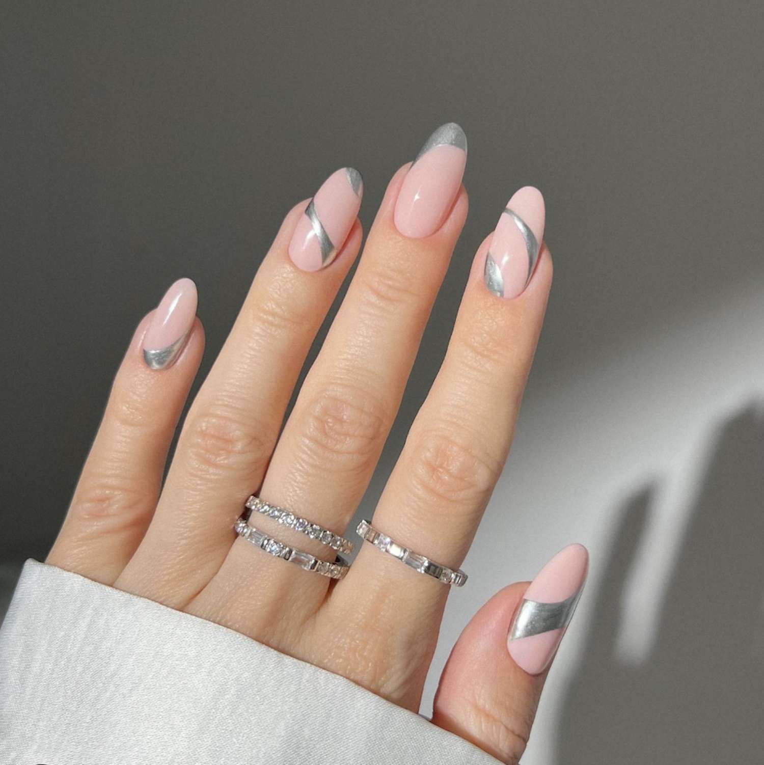 Manicure de rosa pastel com design abstrato de unhas de prata-cromo