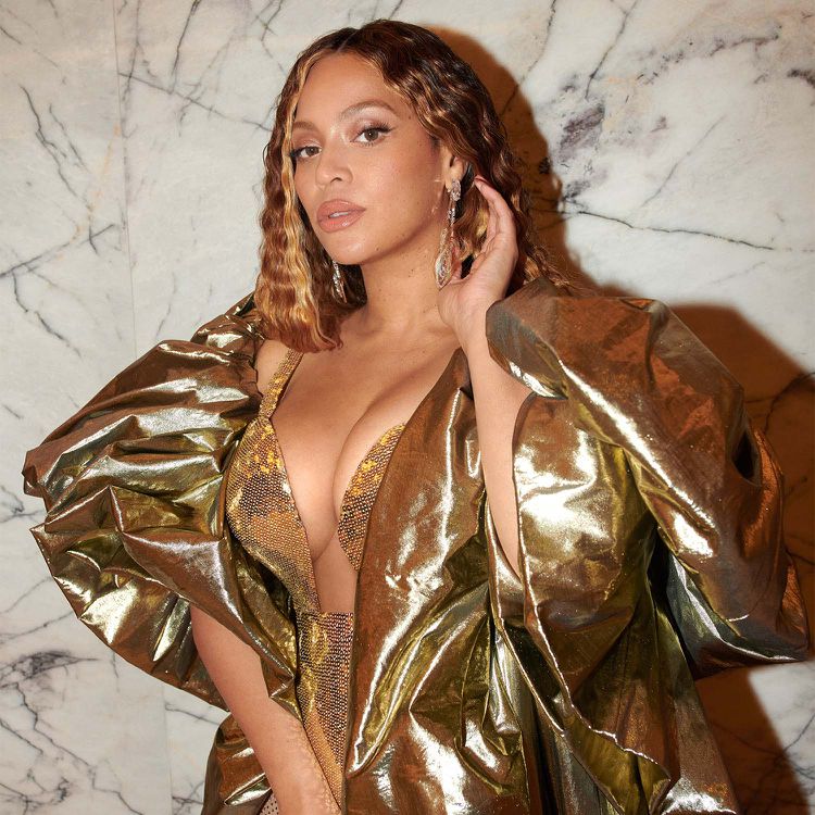 Beyoncé em um vestido de ouro e com brilho em dinheiro