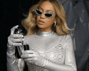 Beyoncé segurando um frasco de perfume prateado