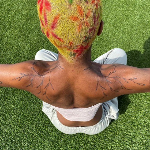 Close-up de tatuagem de videira em dois ombros