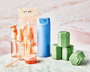 Várias garrafas para produtos de higiene pessoal numa superfície de mármore