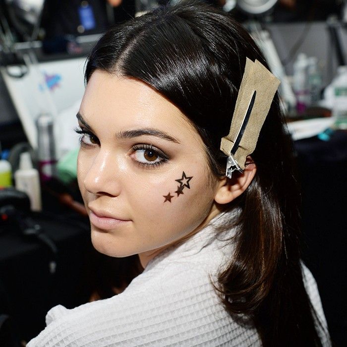 Kendall Jenner com tatuagem temporária no rosto