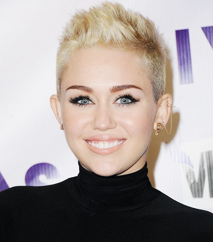 Miley Cyrus usa um penteado curto de duende com um falcão falso
