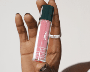 Mão segurando um tubo de Ciele Cosmetics