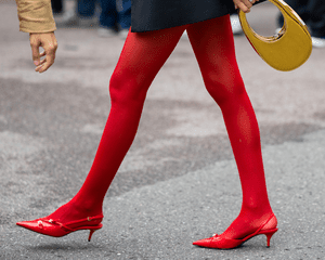 Mulher de meia-calça vermelha, sapatos e bolsa amarela