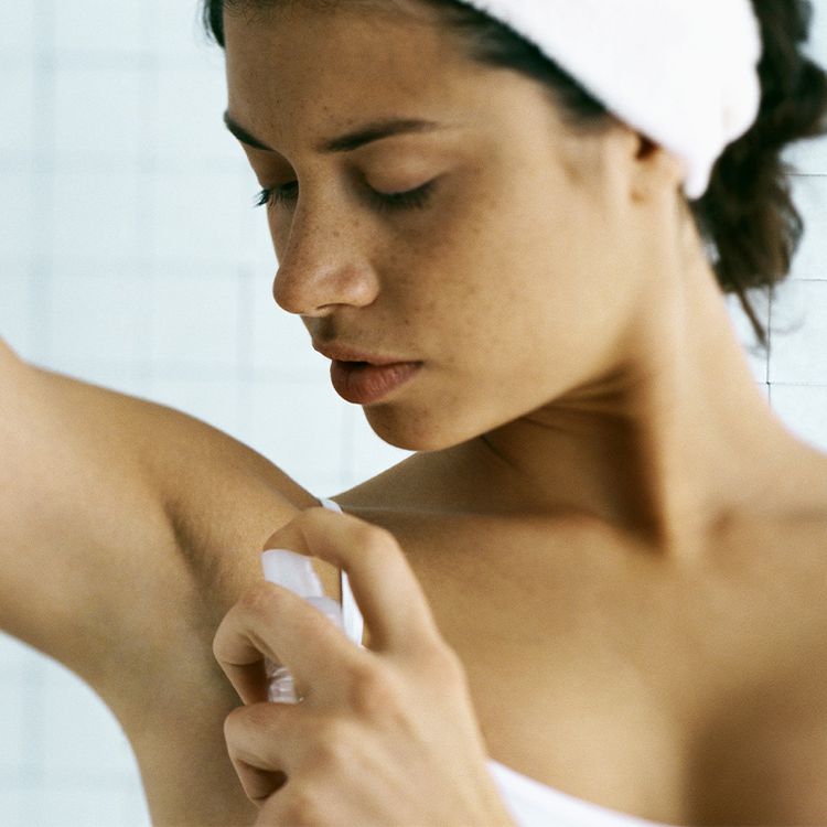 Uma mulher aplica um desodorante