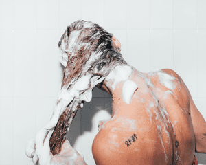 Uma mulher lava os cabelos no chuveiro