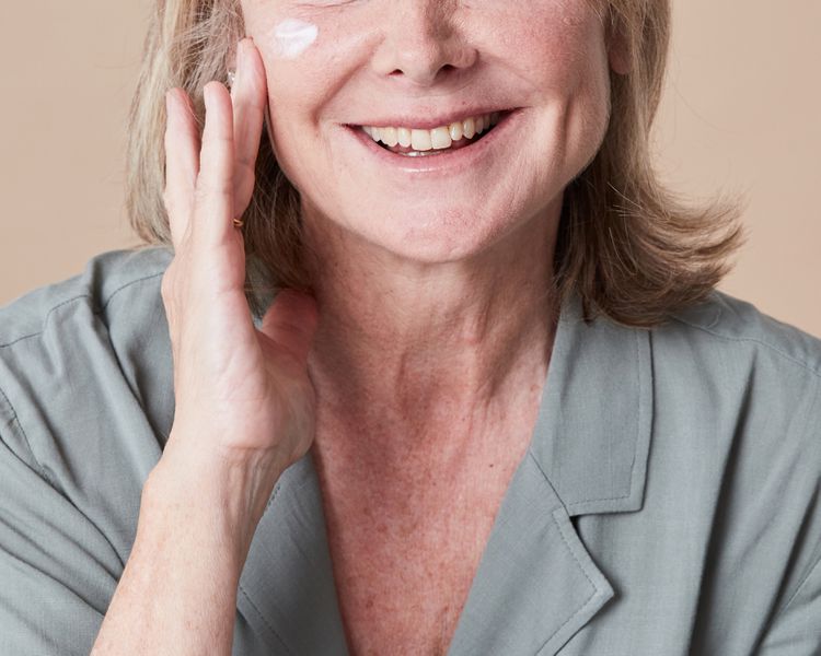 Uma idosa sorridente aplica creme no rosto Khunger N, Mehrotra K. Menopausal acne - problem and solutions. Int J Saúde da Mulher. 2024; 11:555-567. doi:10. 2147/IJWH. S174292