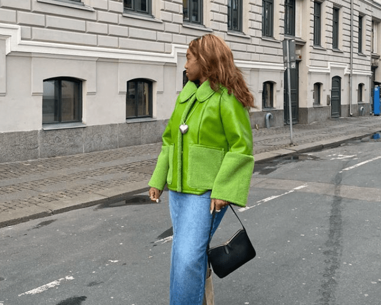 Mulher em um casaco verde e saia jeans-myy